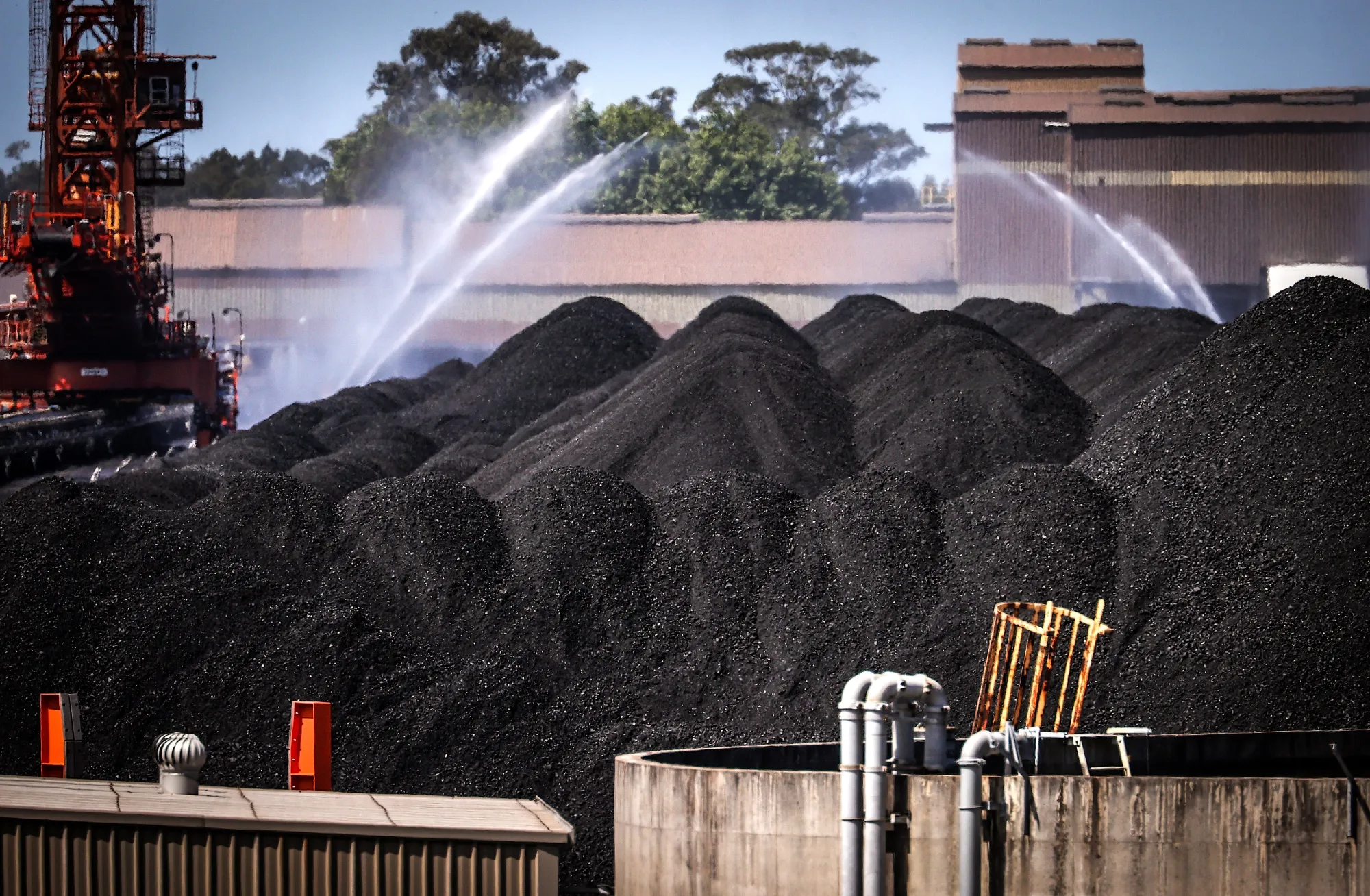 Water is sprayed over piles of coal at the Port of Newcastle in Newcastle, New South Wales, Australia.