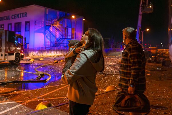 Residents watch emergency services work at the site of a Russian attack in Kyiv, on Nov. 25.