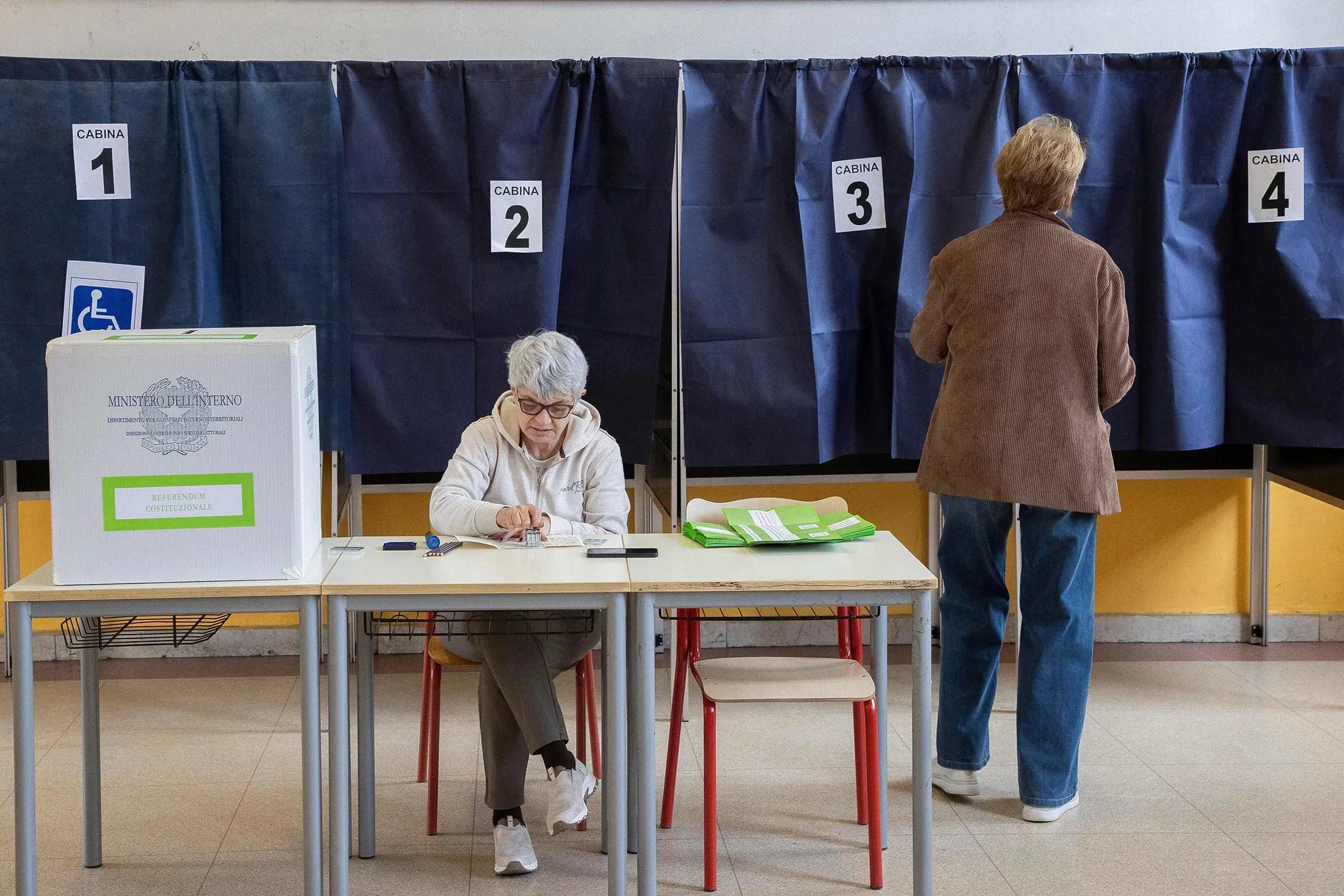 A woman arrives to vote during a referendum on judicial reform, at a polling station in Milan, on March 22.