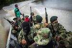 National Liberation Army (ELN) guerrillas patrol the waters of the San Juan River near a remote village in Choco Department, Colombia, in 2017.