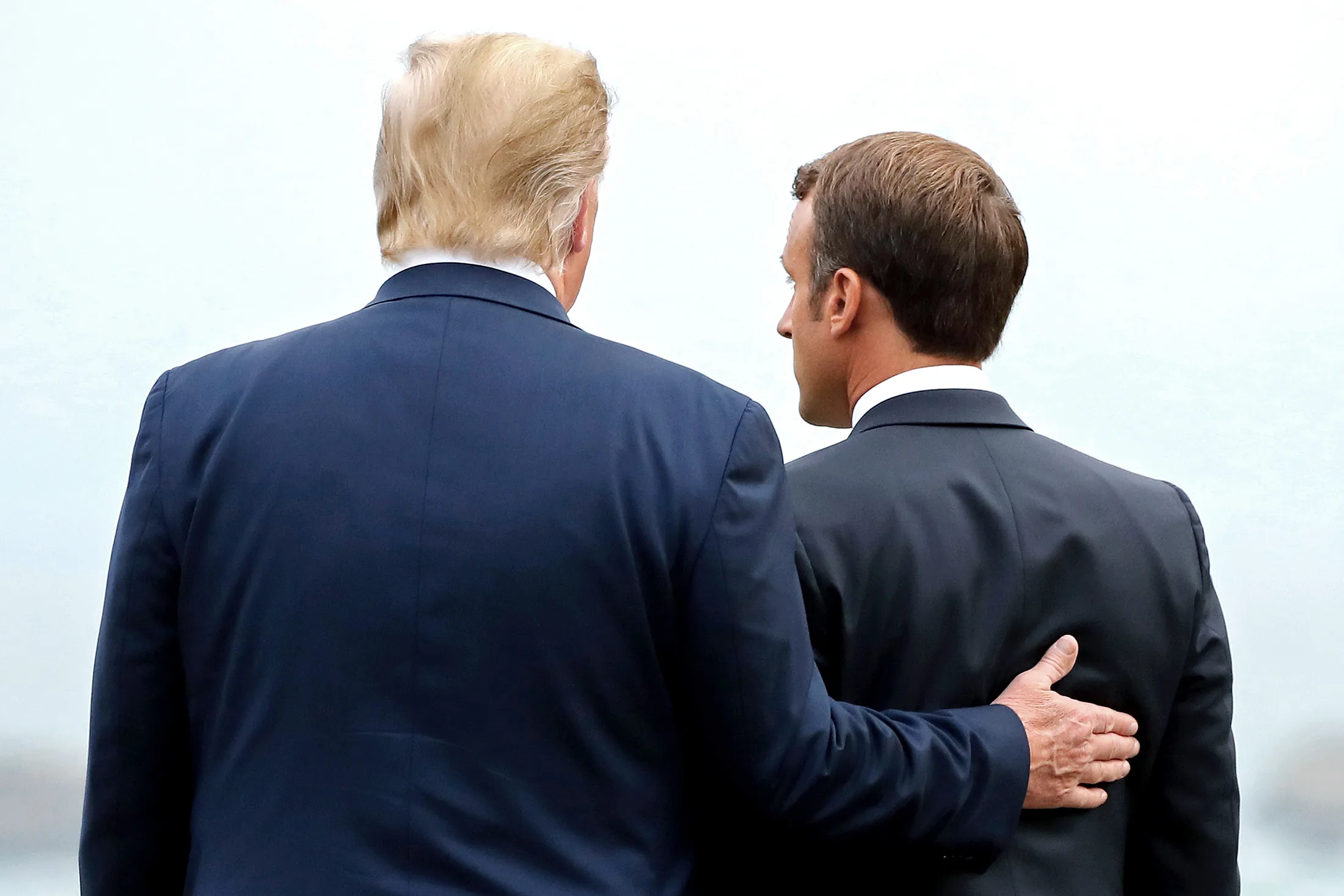 President Trump puts his hand in the back of President Macron ahead of a working dinner at the G-7. 