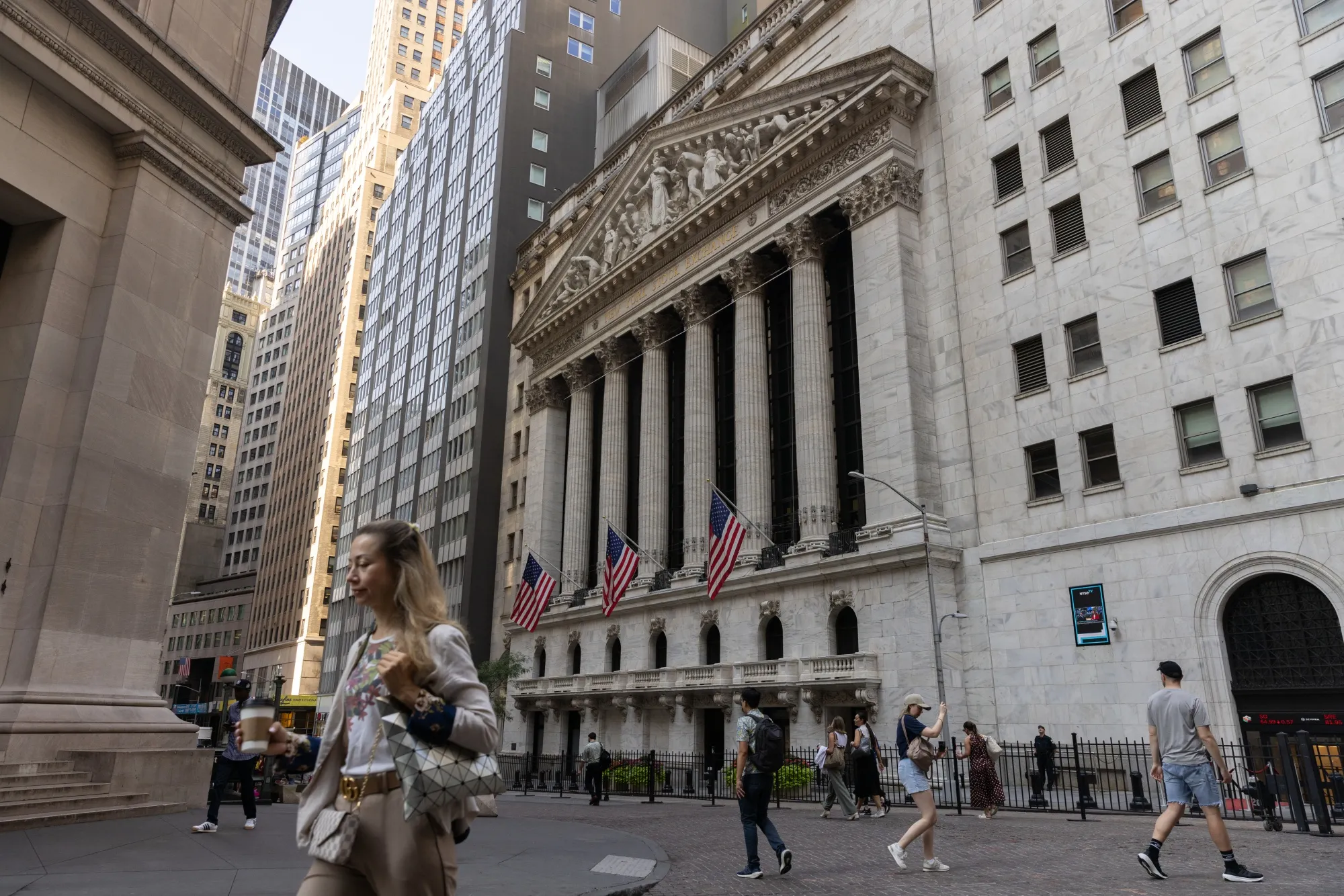 Pedestrians walk along Wall Street near the New York Stock Exchange.