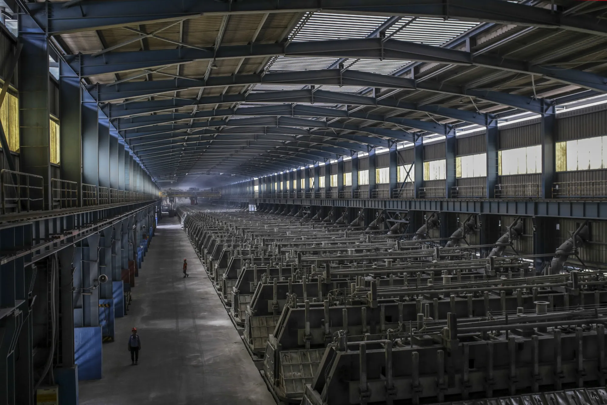 Employees walks past electrolytic cells in the reduction unit of the Vedanta Aluminium Smelter in Jharuguda district, Odisha, India.