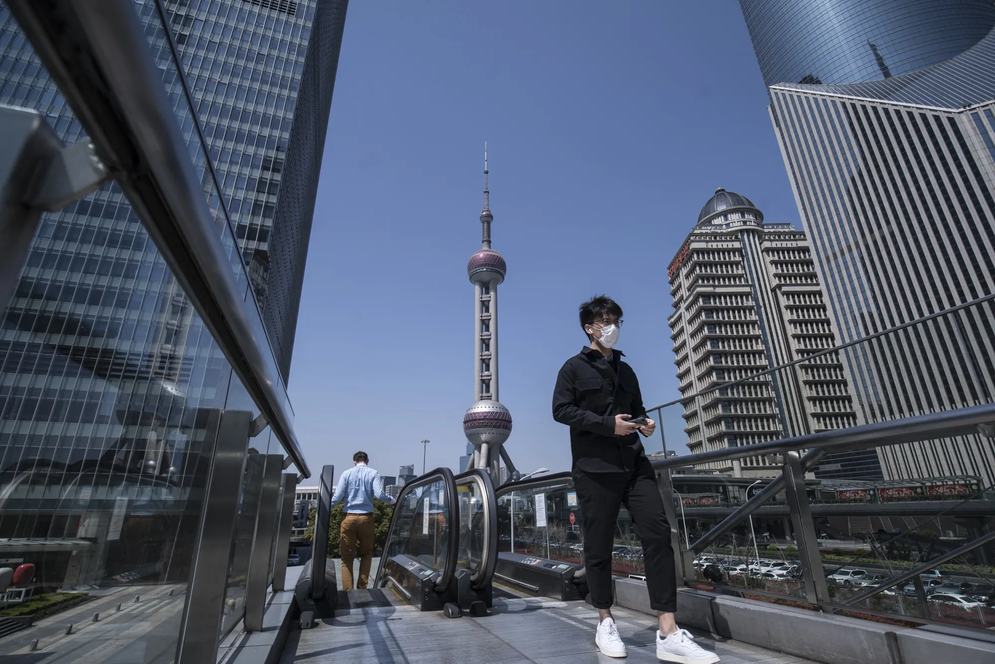 A pedestrian wearing a protective mask walks through the Lujiazui Financial District in Shanghai, China, on&nbsp;March 20.
