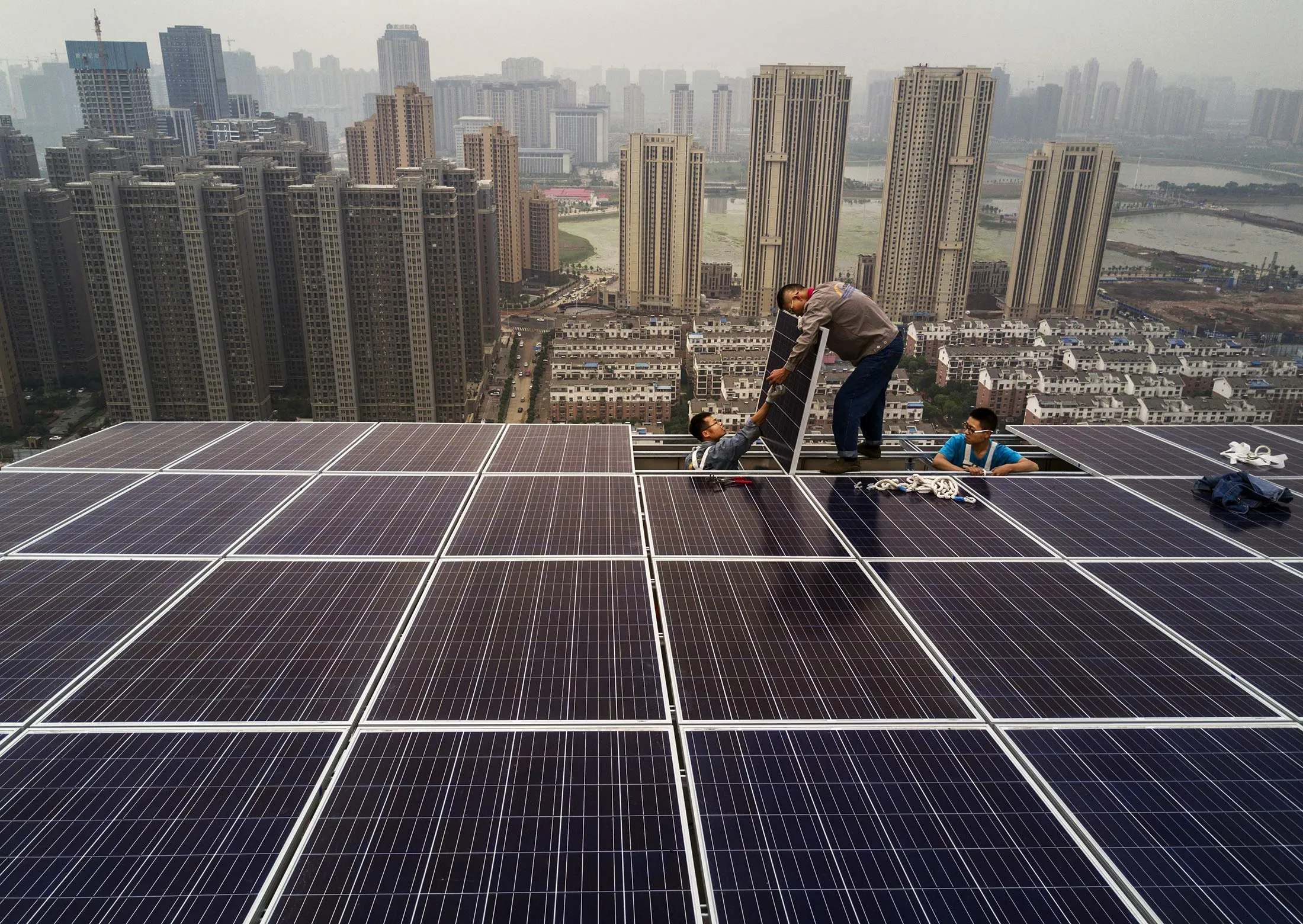 Chinese workers install&nbsp;&nbsp;a solar panel project on the roof of a 47 story building in Wuhan, China on May 15.&nbsp;
