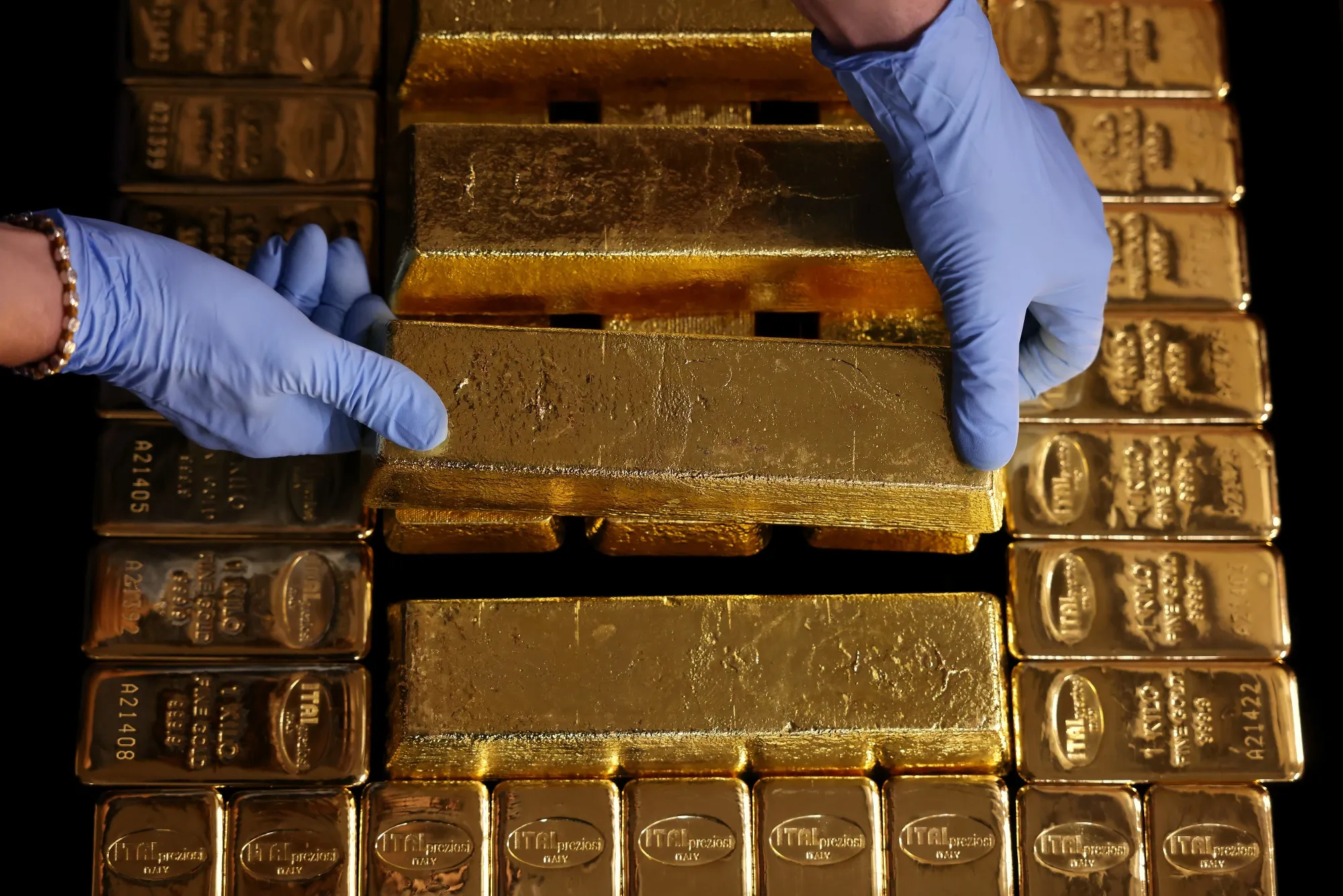 An employee arranges gold bars at a refinery in Arezzo, Italy.