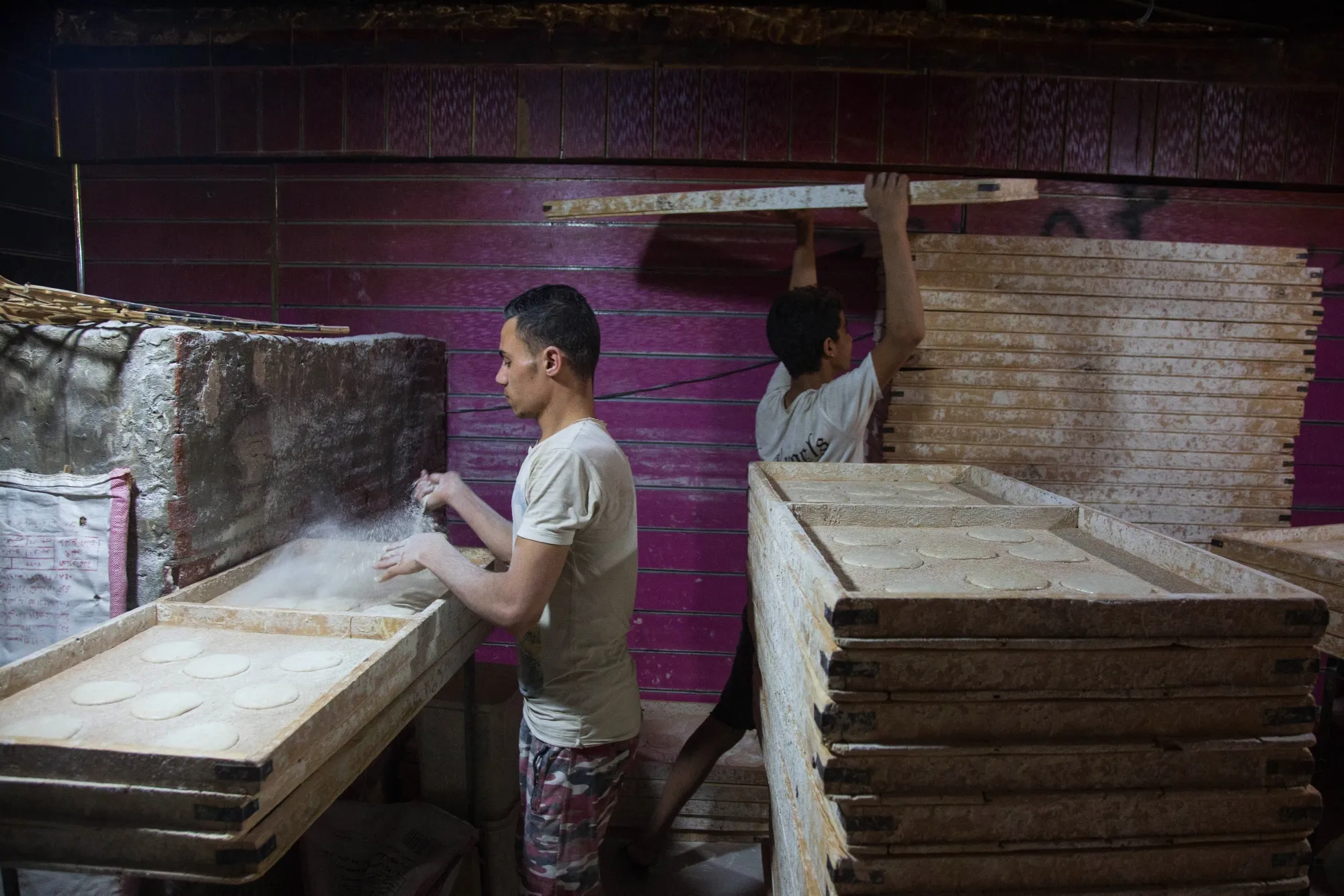 Workers prepare dough for bread in a bakery at the Al-Monira market in Cairo.