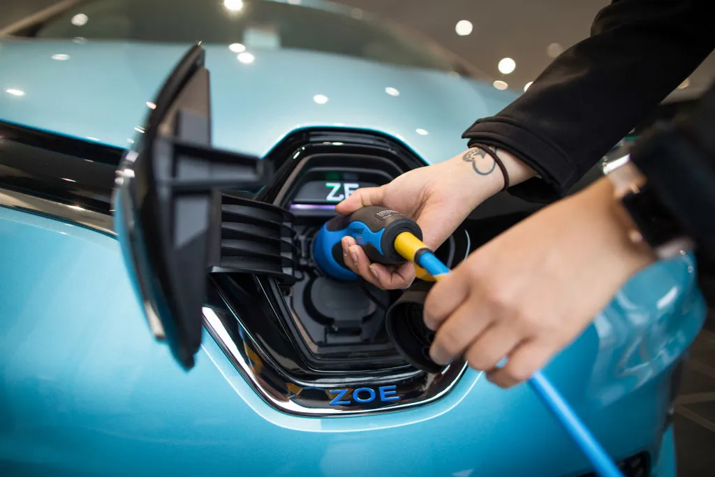 An employee connects an electric charger at a dealership&nbsp;in Lincoln, UK.