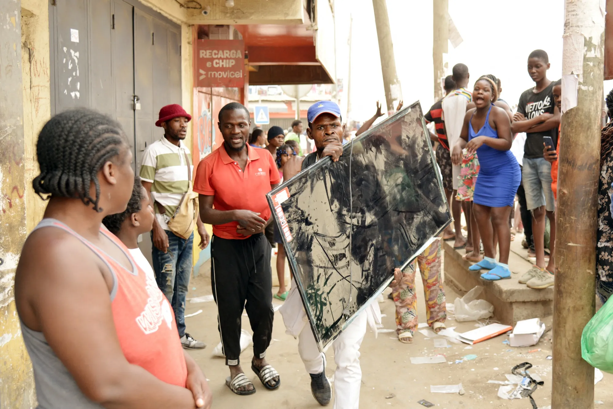 A man carries a television during looting in the Kalemba 2 district of Luanda on July 28.