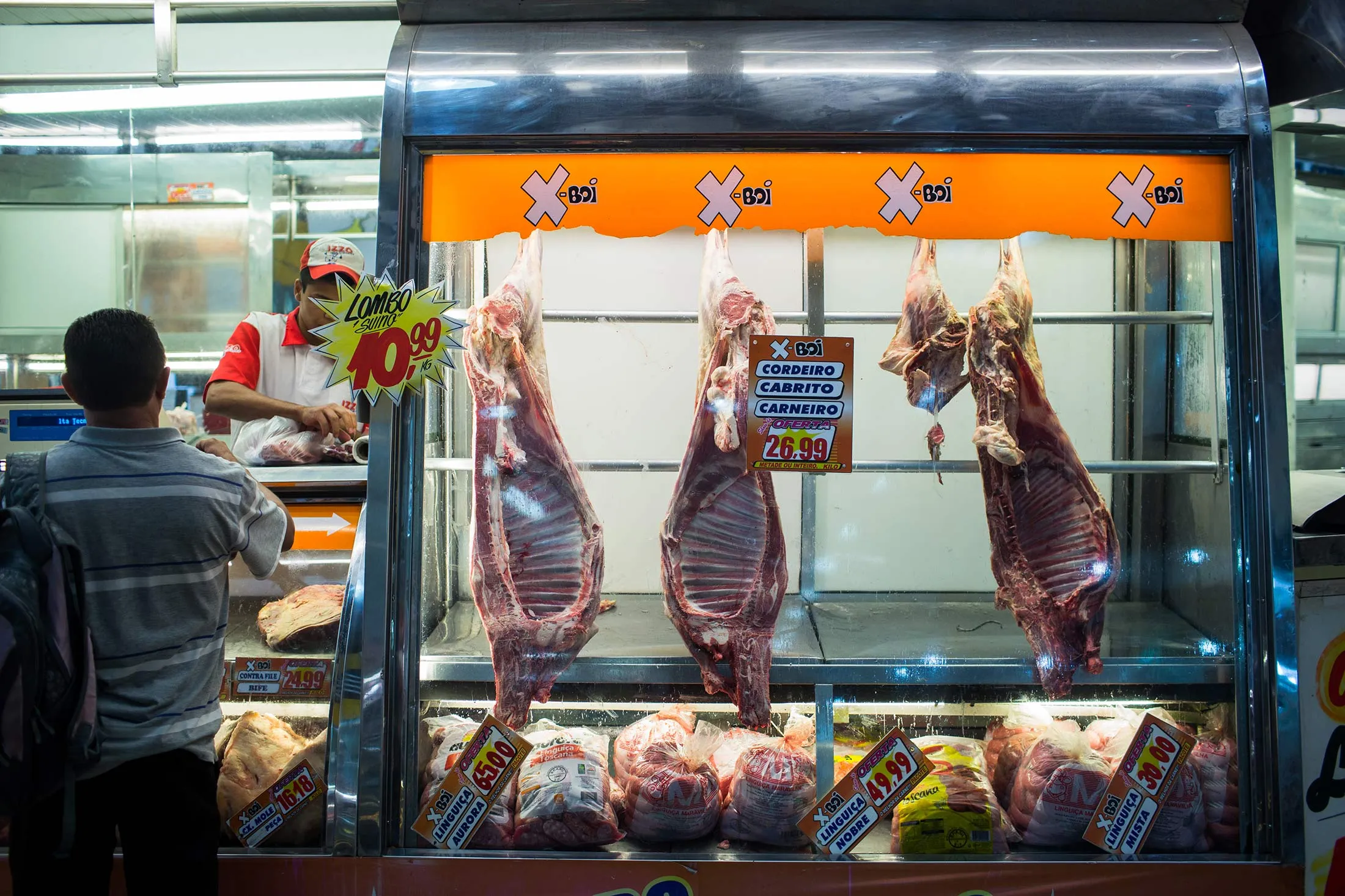 A customer buys meat from a butcher inside a market in Sao Paulo, Brazil, on Saturday, March 18, 2017.
