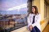 Portrait photograph of Doctor Ashley Montgomery Yates, who runs University of Kentucky Health Care’s intensive care unit and oversees inpatient care. She is seated on a window sill and looking out the window several floors above ground-level at the medical center.