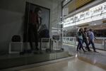 People walk past a closed store at a mall in Caracas. Shopping centers are scaling back hours of operation to save energy, causing an uproar among consumers.