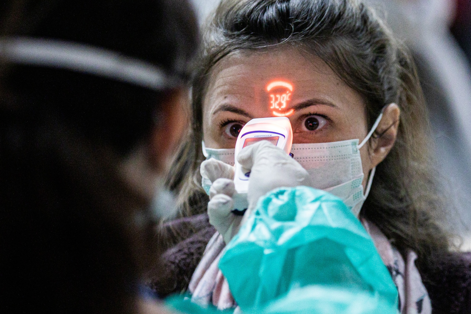 A health worker screens a passenger arriving from Italy at Debrecen International Airport, Hungary, on Feb. 24.