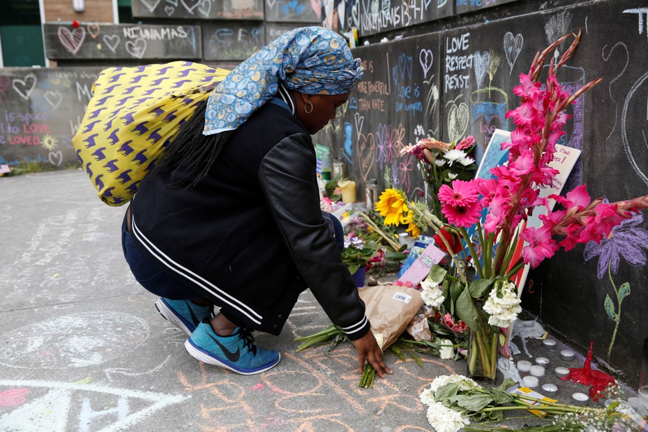 A Muslim woman, who preferred not to giver her name, prays at a makeshift memorial for two men who were killed on a commuter train while trying to stop another man from harassing two young women who appeared to be Muslim.