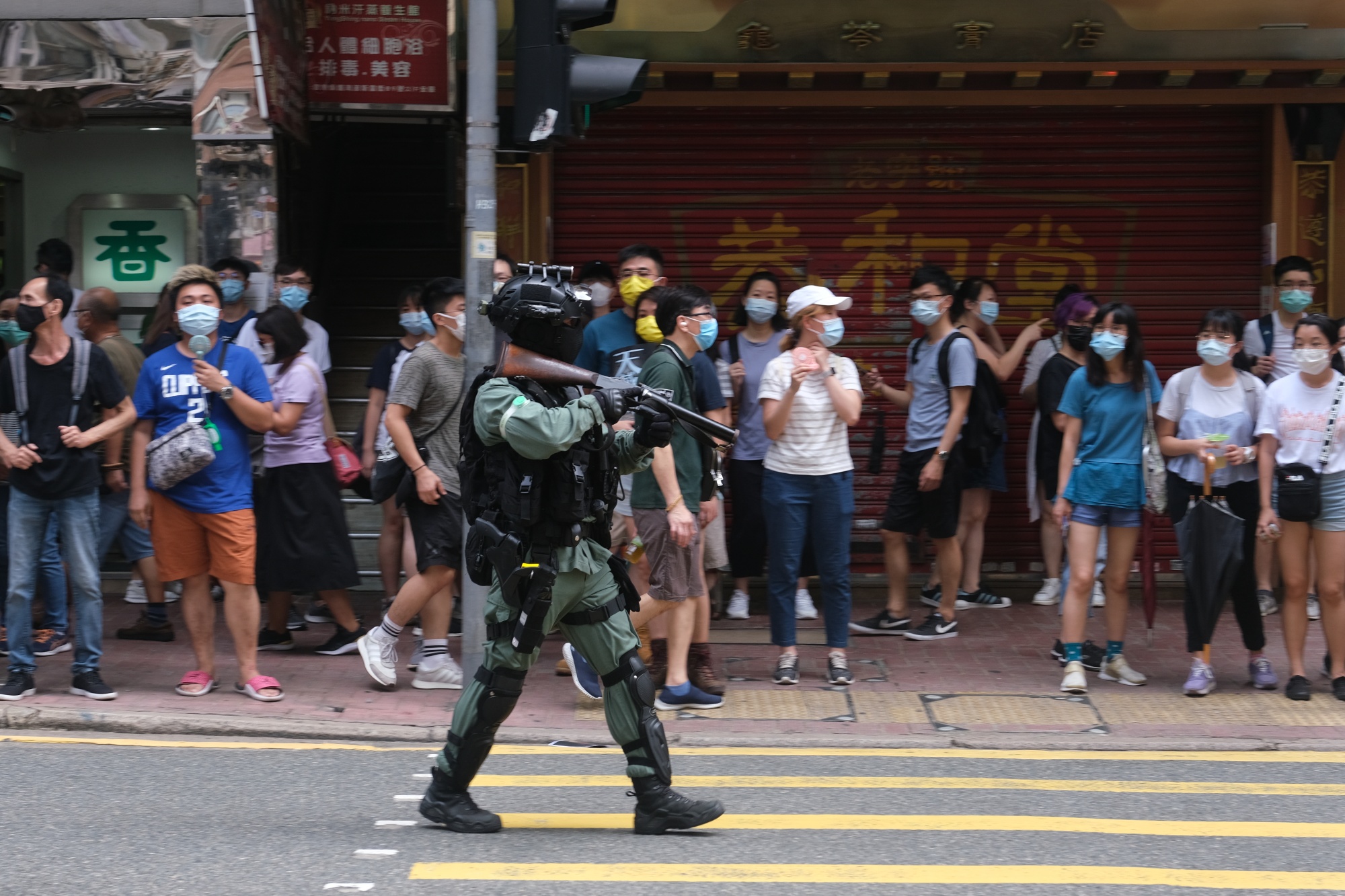A riot police officer points a tear gas rifle towards demonstrators in Hong Kong, on July 1.