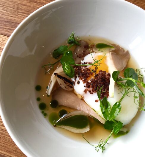 A poached egg with pea shoots and mushroom broth.