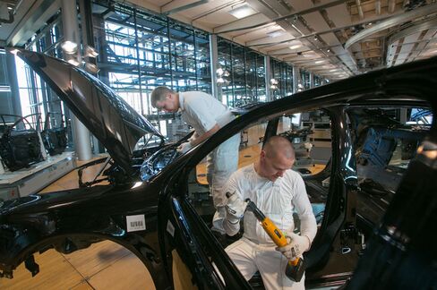 Employees assemble the body shell of a Volkswagen Phaeton automobile on the production line at the Volkswagen AG factory in Dresden, Germany.