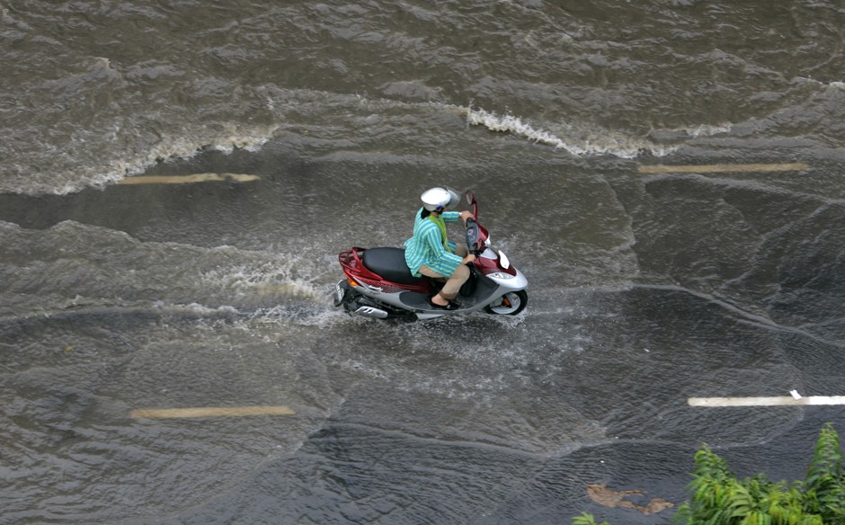 A motorcyclist rides through a road inundated by rainwater in Dhaka, Bangladesh, where NASA and USAID are using satellite data to help the densely populated country better prepare for extreme floods.