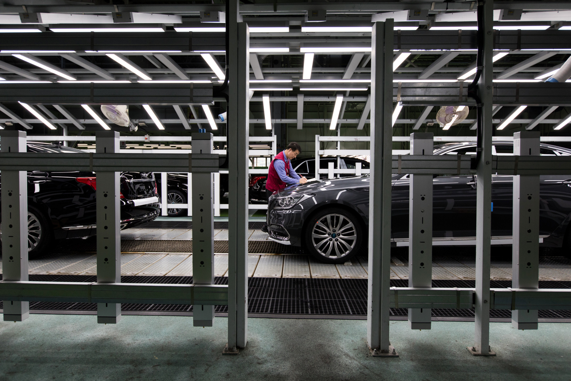 An employee make notes as he performs final inspections on a Hyundai Motor Co. Genesis luxury sedan on the production line&nbsp;in Ulsan.