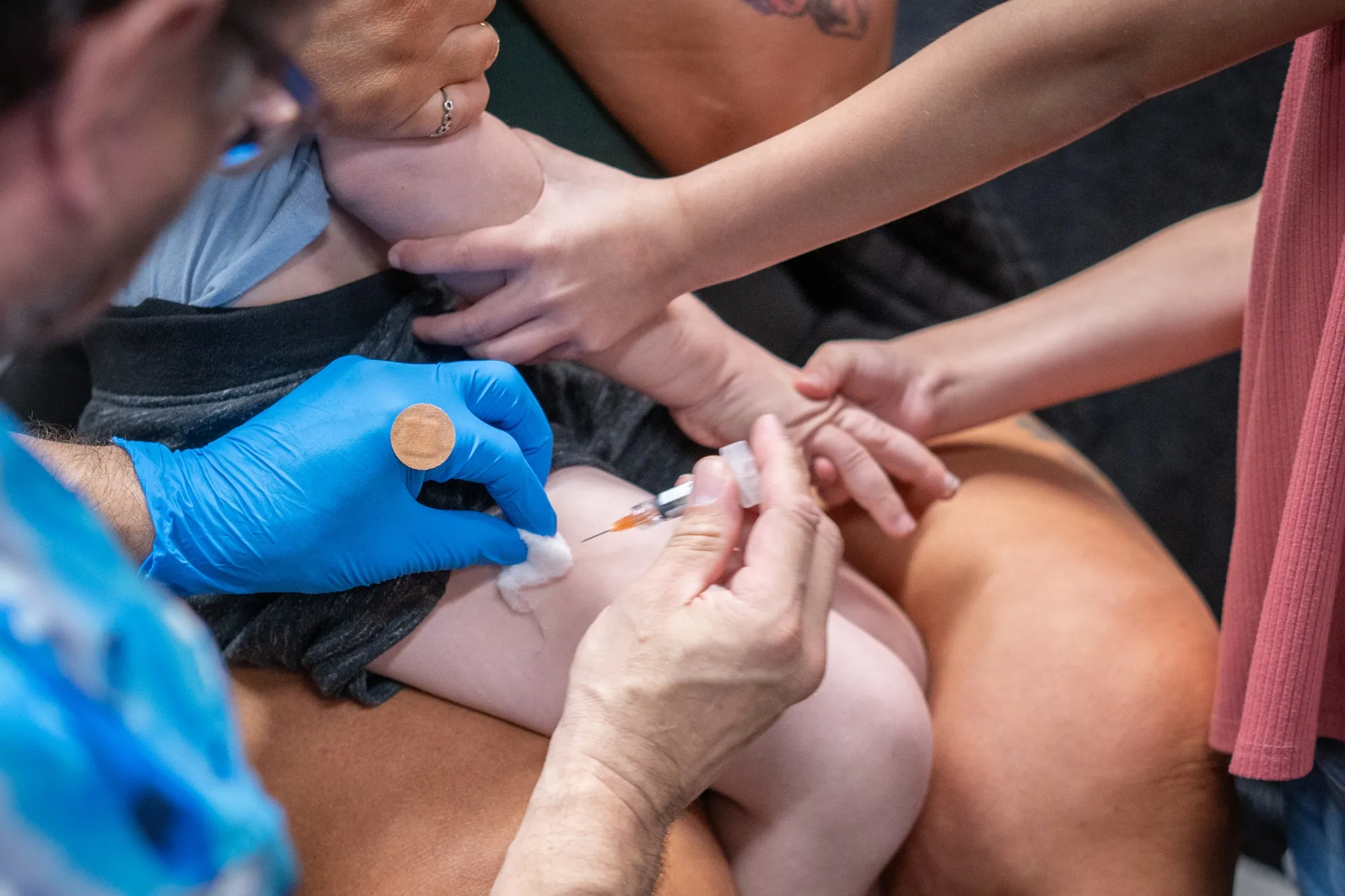 A family supports a young child as he receives the MMR vaccine at a&nbsp;clinic setup by the Lubbock Public Health Department amid a rise in cases in West Texas, in&nbsp;2025.