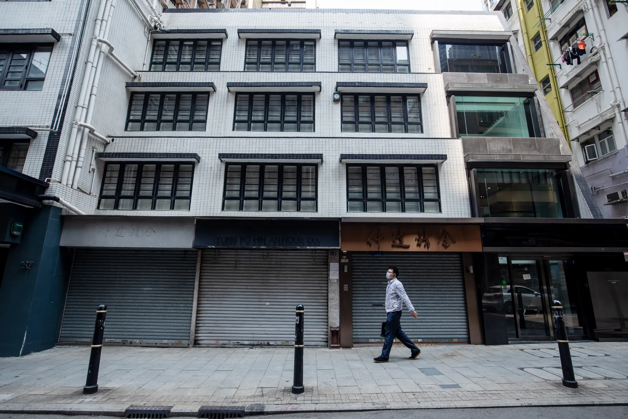 A man walks past a closed store on Hollywood Road in Hong Kong, on March 16, 2020.