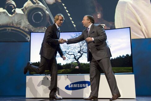 Michael Bay, left, greets Joe Stinziano, executive vice president of Samsung Electronics America, during a press conference at CES 2014.