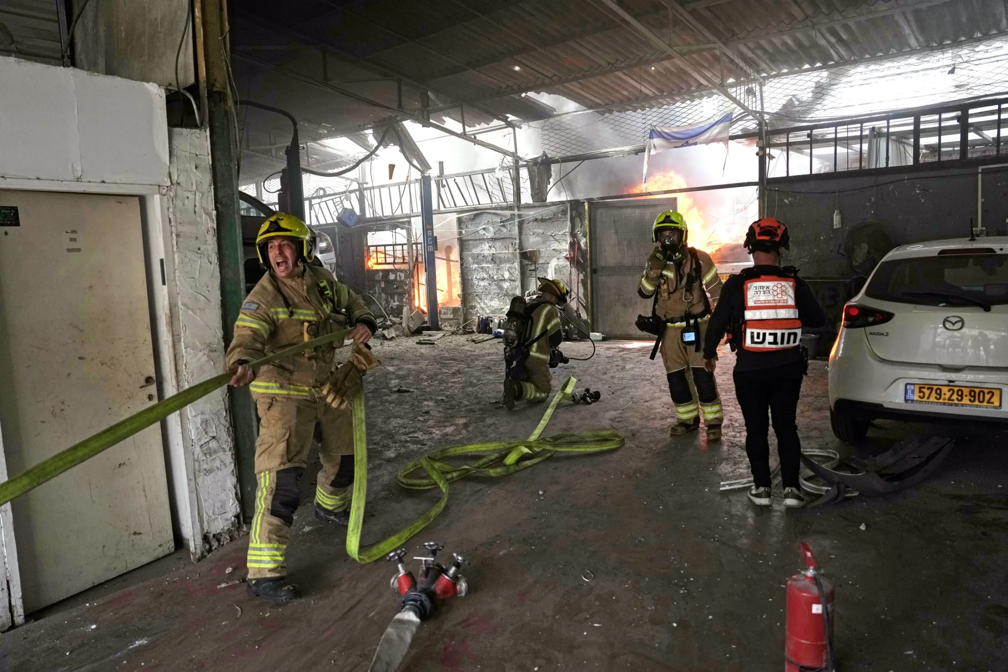 Firefighters tackle a blaze following an Iranian strike in Petah Tikva, Israel, on March 31.