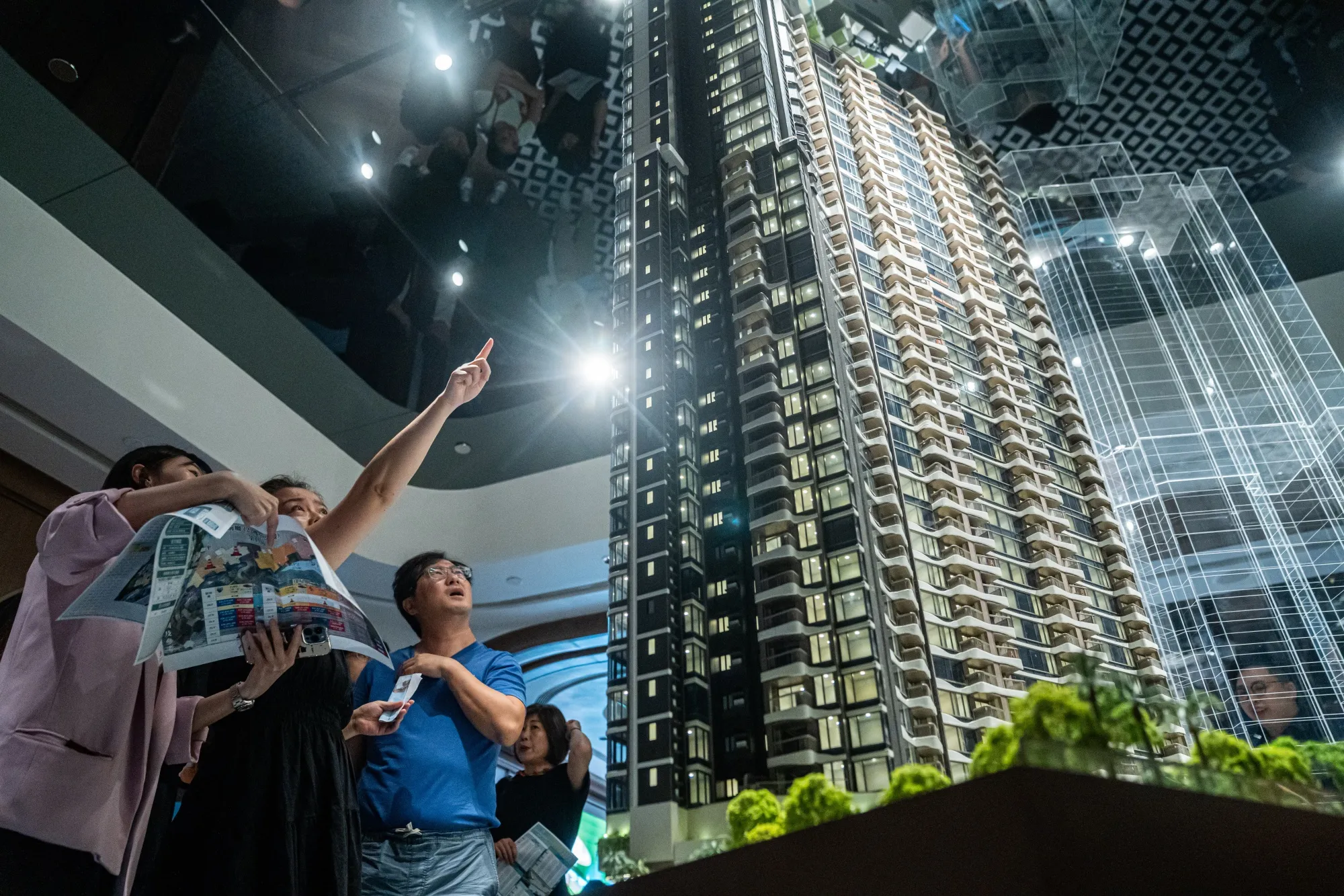 Prospective buyers look at a model of the Deep Water Pavilia project, developed by New World Development Co., in Hong Kong&nbsp;on&nbsp;June&nbsp;7.