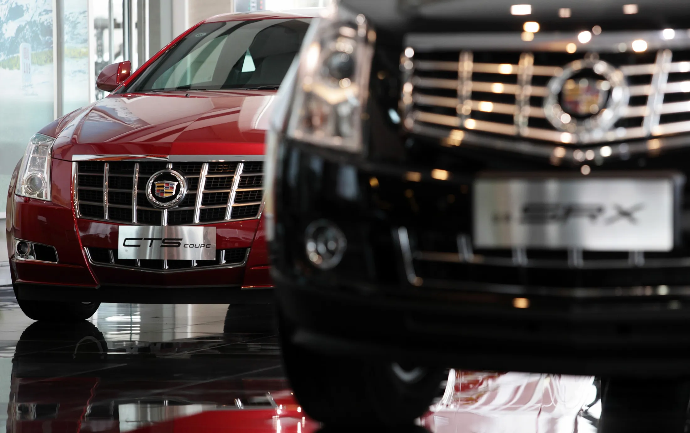 General Motors Co. Cadillac CTS, left, and SRX vehicles are displayed at a dealership in Shanghai.
