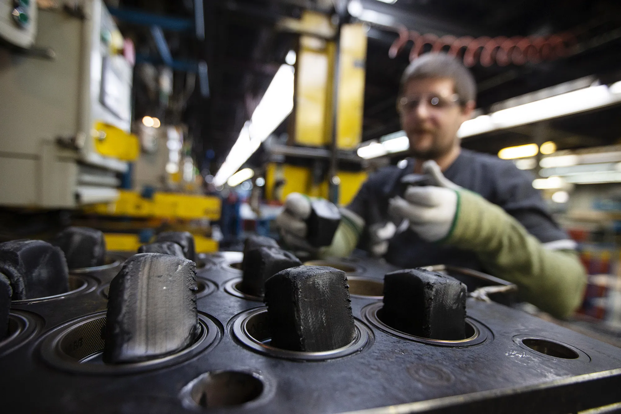 Cooled hockey puck blanks are placed into a mold at a plant in St-Jerome, Quebec, Canada.