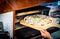 The brick-lined commercial-grade pizza oven enables pi to crank out four pizzas every fifteen minutes.