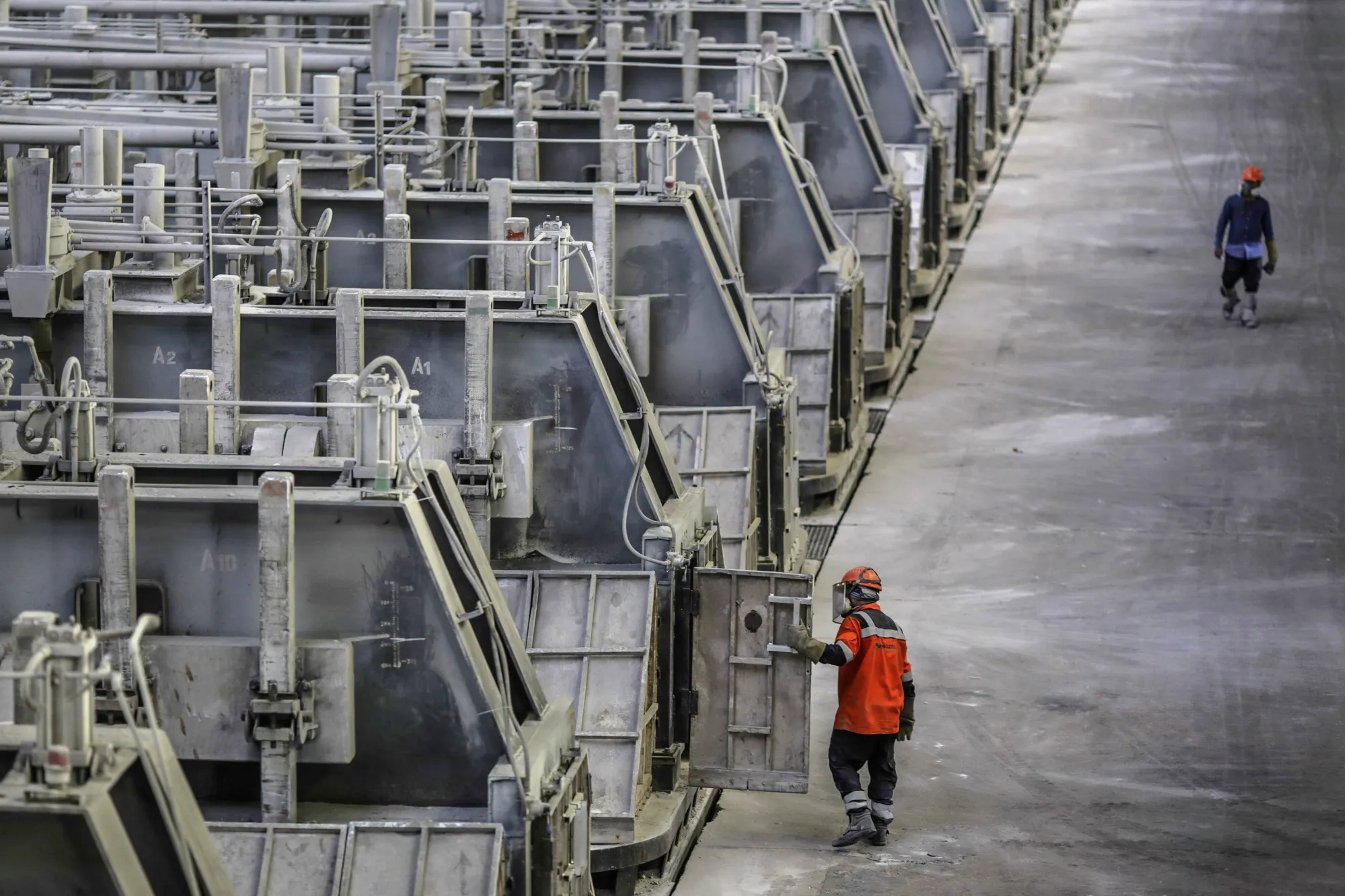 An employees closes the door of a electrolytic cell in the reduction unit of the Vedanta Ltd. Aluminium Smelter in Jharuguda district, Odisha, India.
