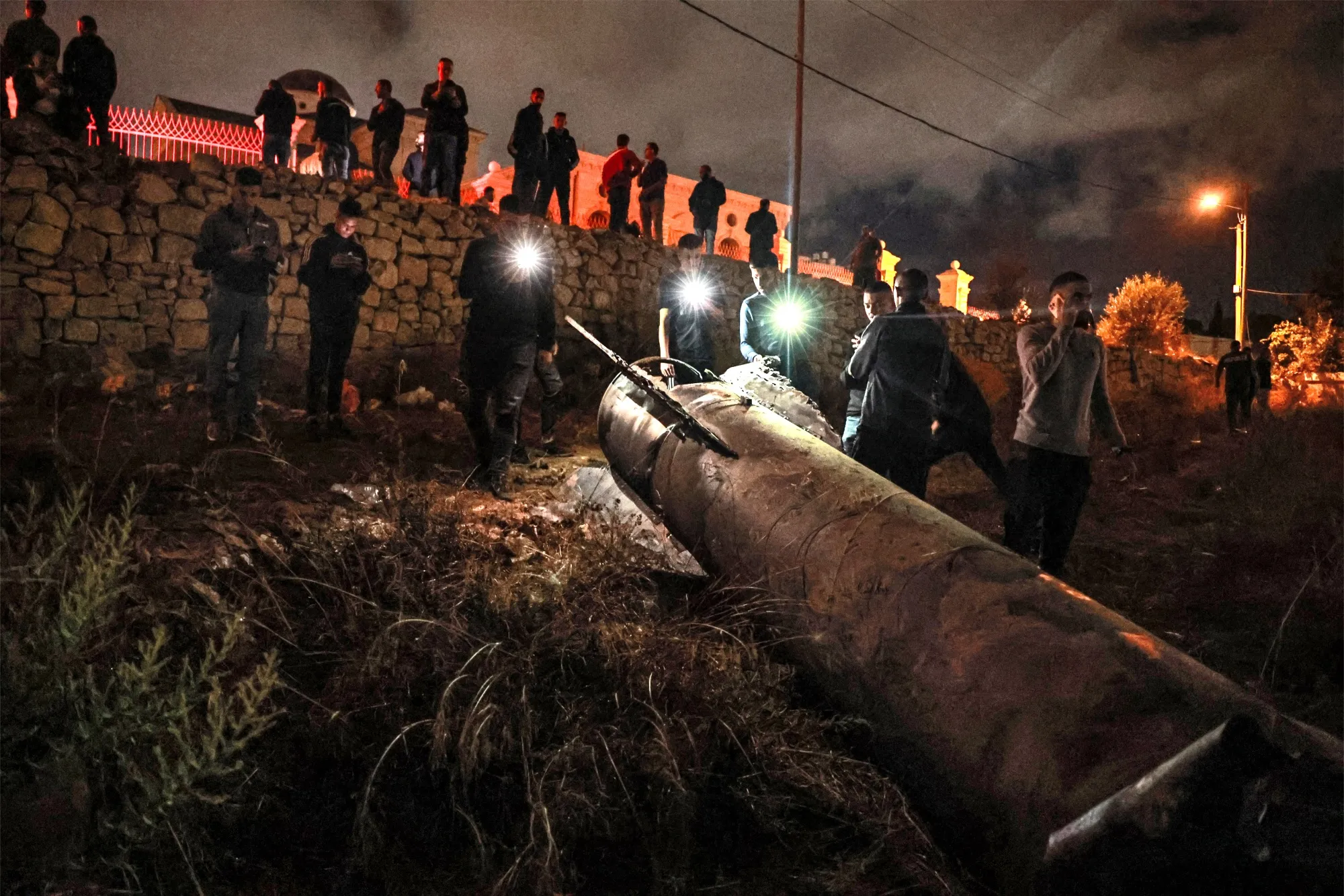 Palestinian youths inspect a fallen projectile after Iran launched a barrage of missiles at Israel&nbsp;in Ramallah in the occupied West Bank on Oct. 1.
