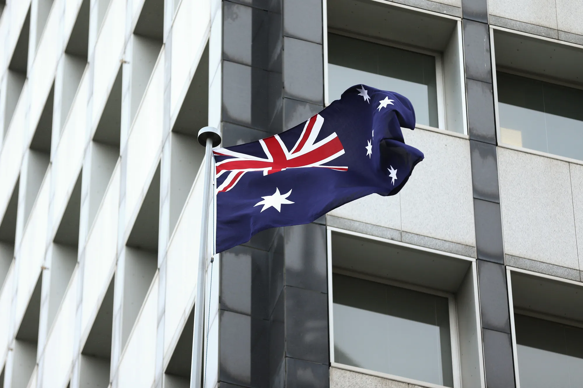 The Australian flag flies outside the Reserve Bank of Australia (RBA) headquarters in Sydney, Australia, on Monday, Dec. 4, 2017. Australia's central bank is on track for its longest stretch of unchanged interest rates as it bets a tightening job market will begin to put upward pressure on wages -- at some stage.