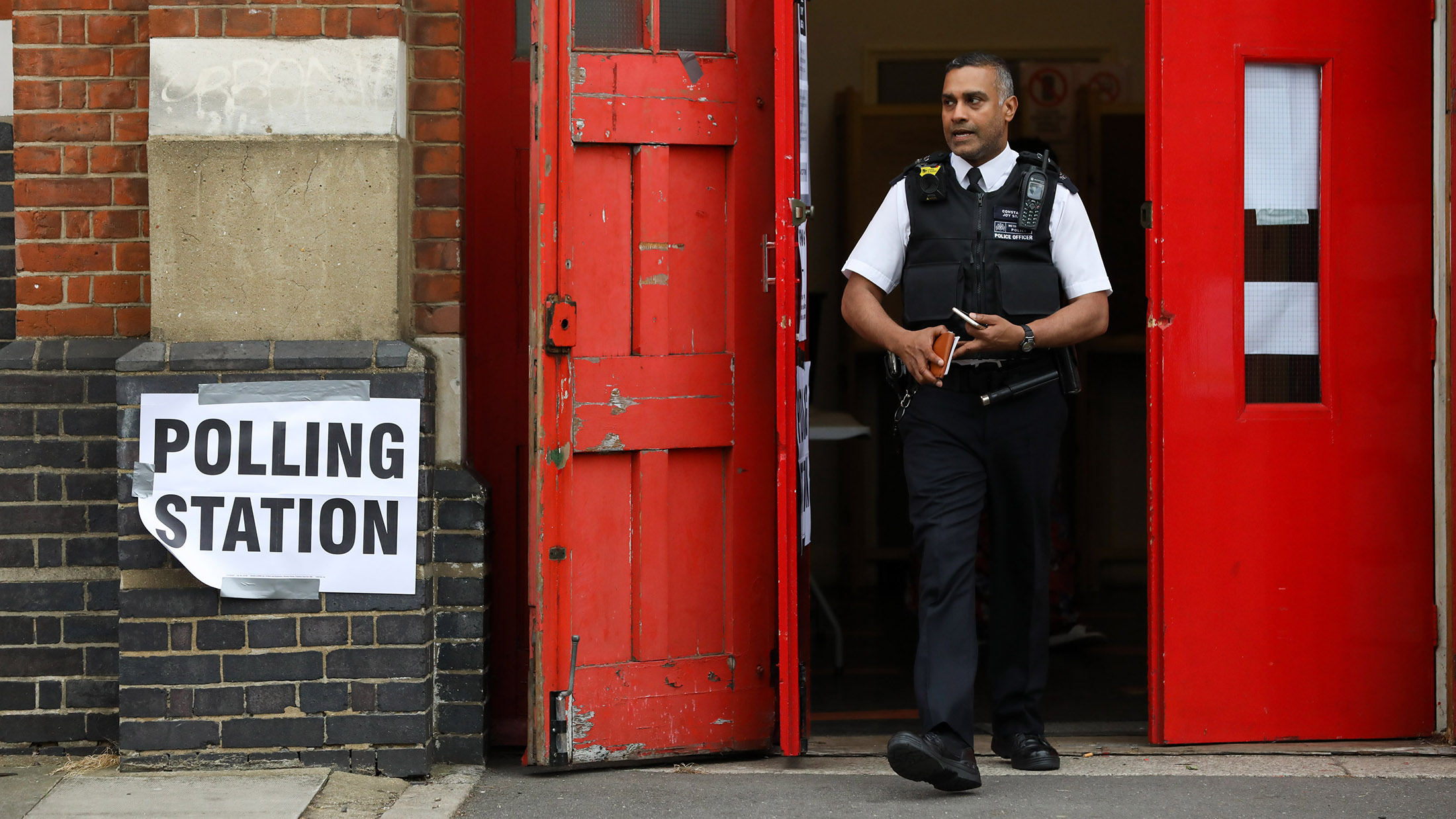 A police officer leave the a polling station for the general election at The Old Fire Station in the Stoke Newington district of London, U.K., on Thursday, June 8, 2017. Britons vote today after an election dominated by Brexit, austerity and in the closing phases, security.
