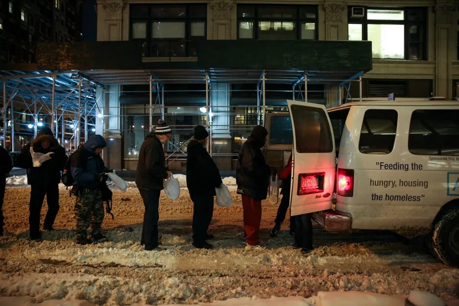 People stand in line as Coalition for the Homeless delivers supplies to homeless people as part of their weekly distribution in New York City, on January 4, 2018.