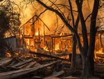 Flames engulf a home as it burns along Highway 128 during the Kincade fire in Healdsburg, California, in Oct. 2019.