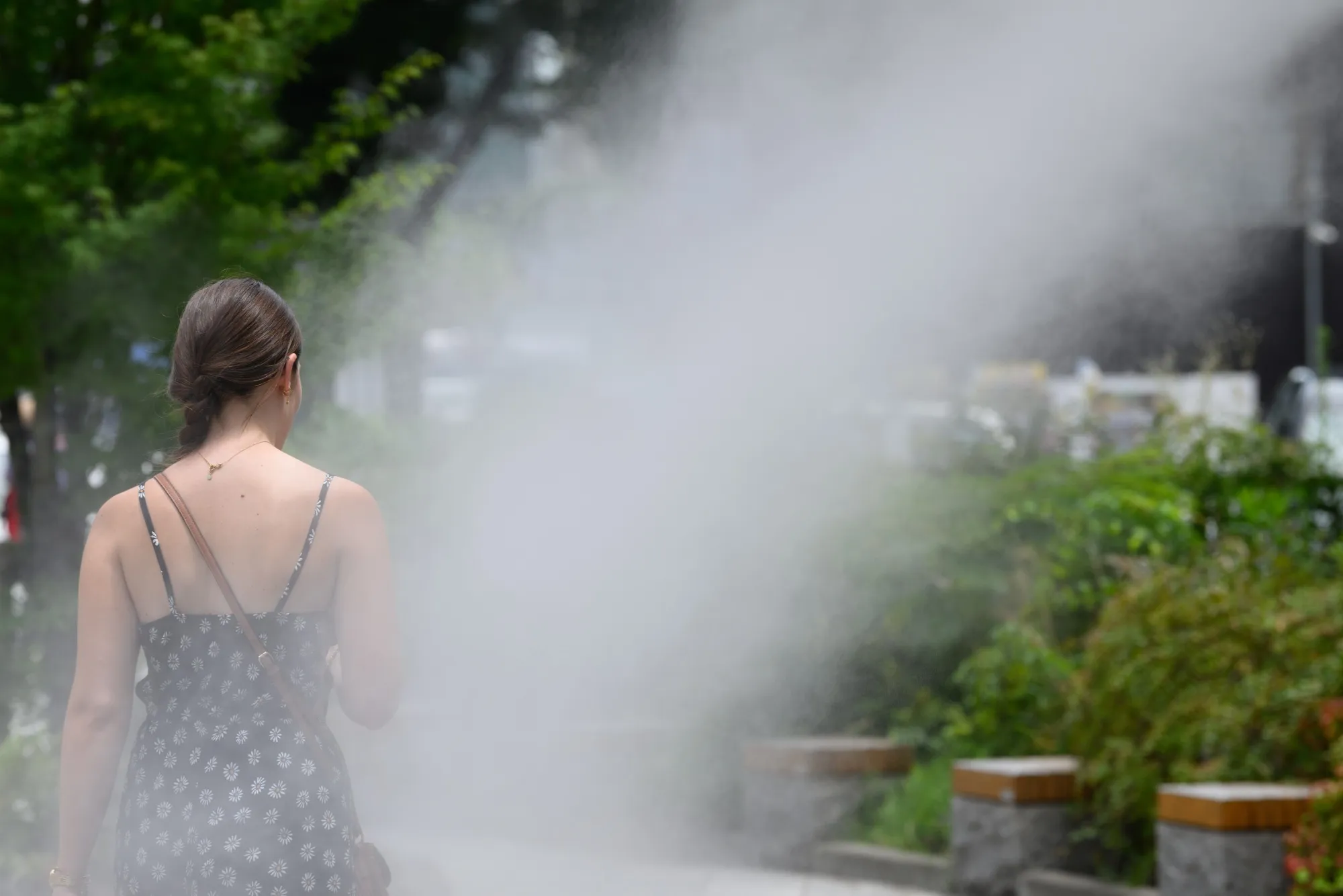 A pedestrian under cooling mist sprays in the Ginza district of Tokyo.