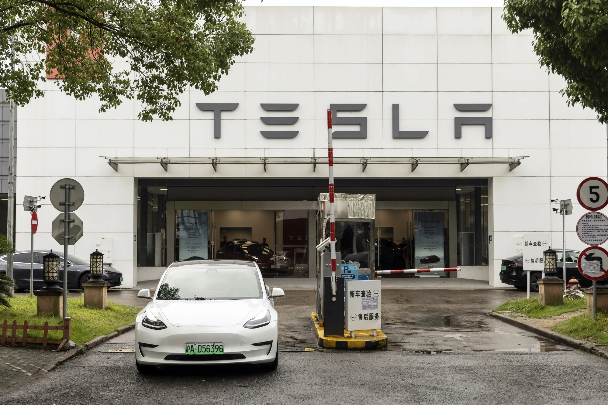 A Tesla Inc. Model 3 electric vehicle leaves one of the automaker's dealership in Shanghai.