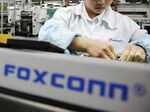 Employees work on the assembly line at Hon Hai Group’s Foxconn plant in Shenzhen, China.