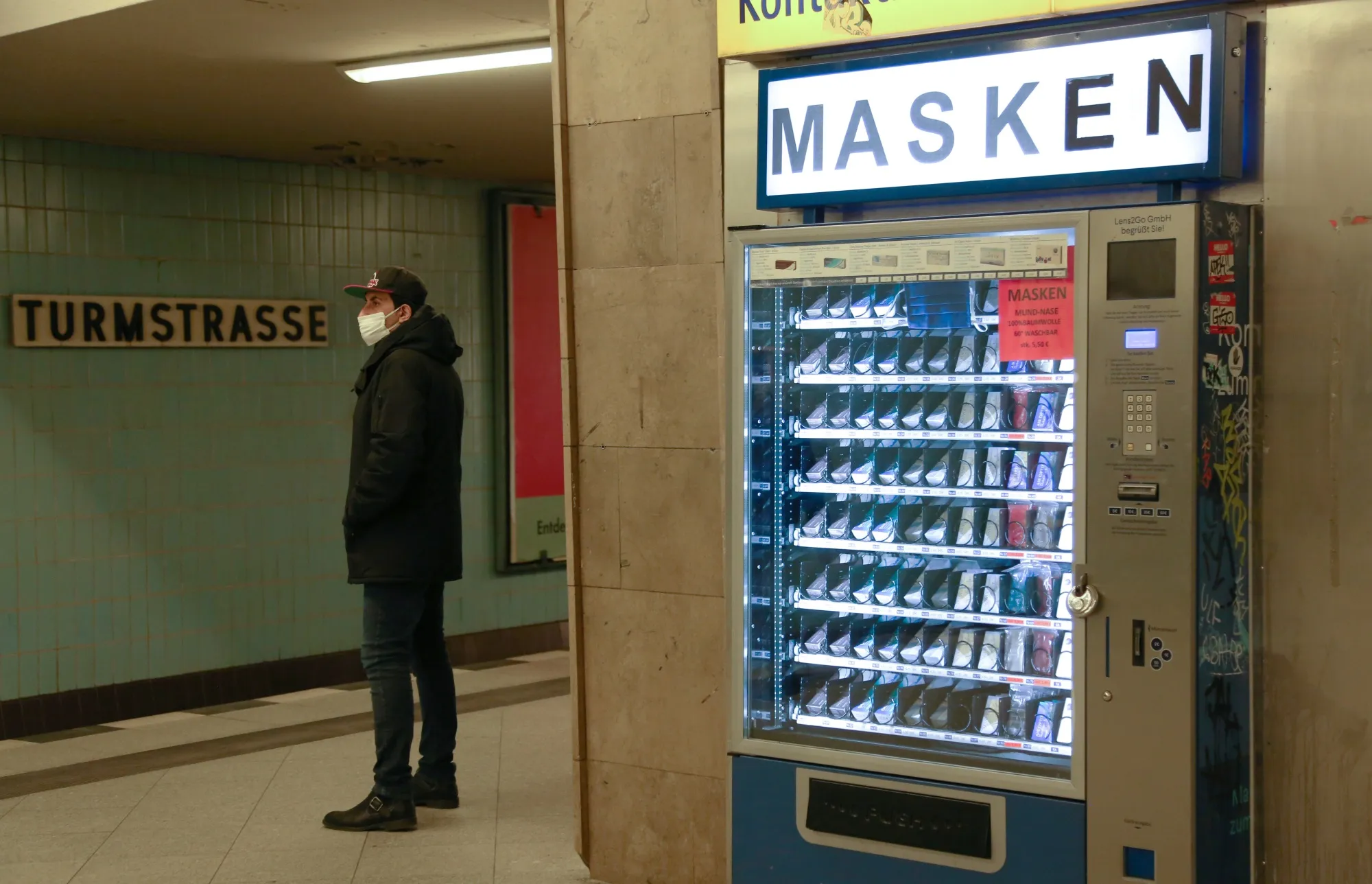 A traveller waits&nbsp;near a vending machine selling&nbsp;face masks in&nbsp;train station in Berlin.