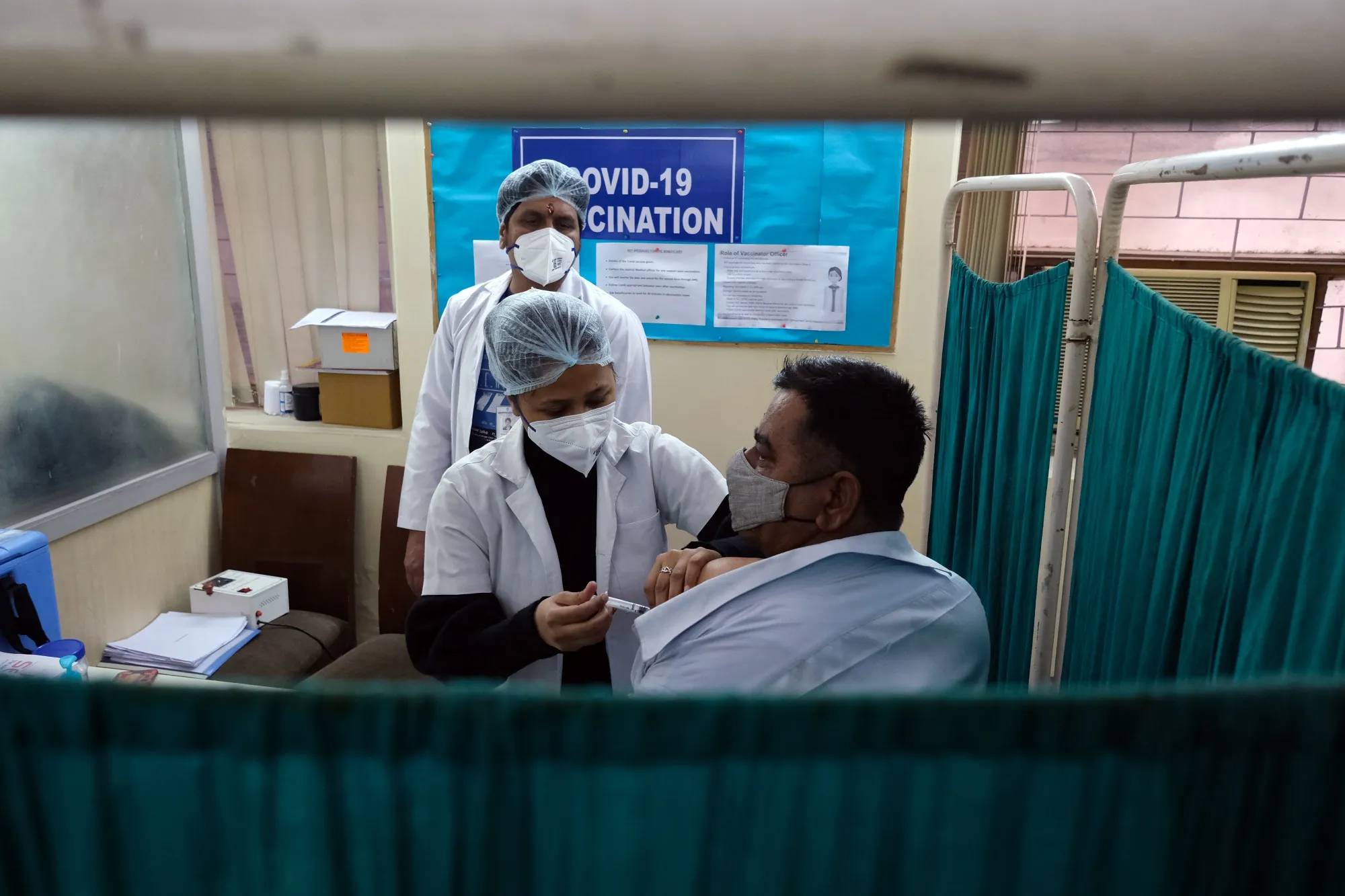 Healthcare workers administer a vaccine for coronavirus at Sanjeevan Hospital in Daryaganj, New Delhi.