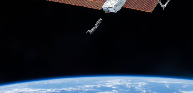 Two Planet Labs Inc. satellites being ejected into low-Earth orbit from the International Space Station.