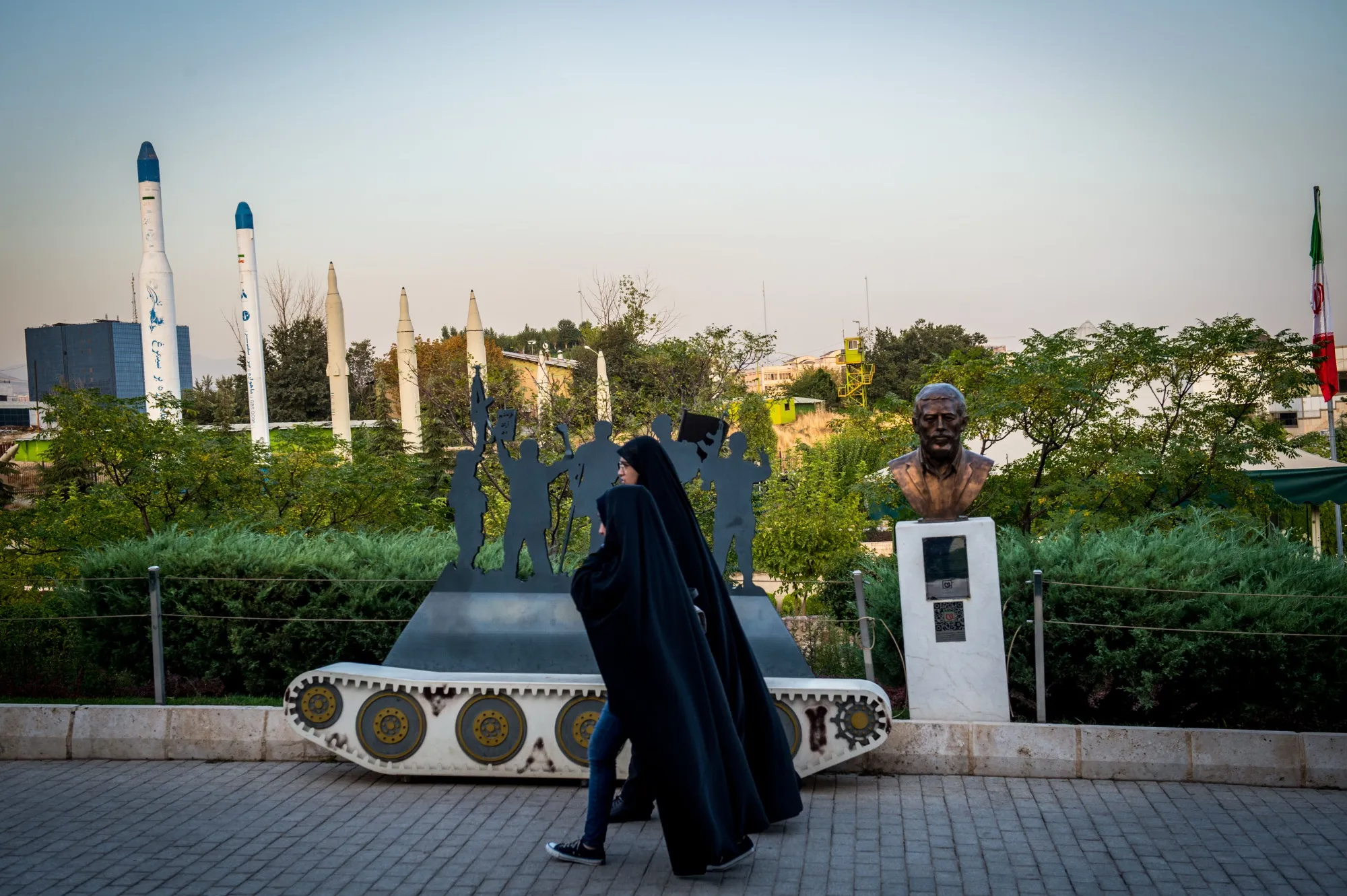 Two women walk through the missile display section of a military museum in Tehran, Iran