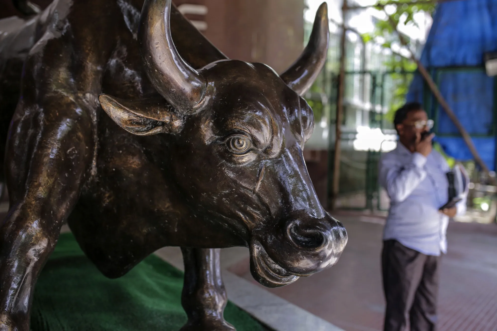 A bronze bull statue stands at the entrance to the Bombay Stock Exchange building in Mumbai, India.