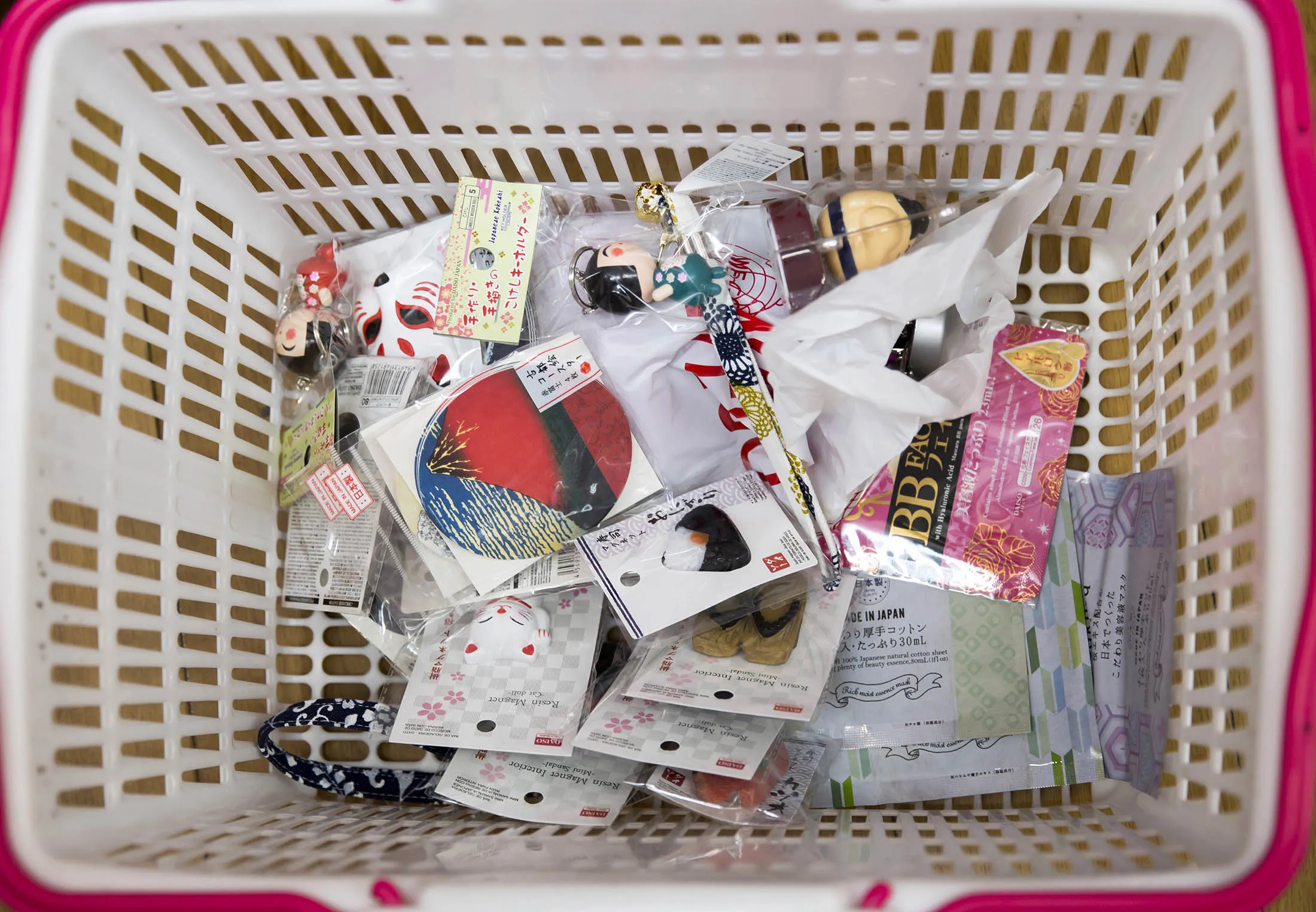100 yen products are stacked in a customer's basket at the Daiso store, operated by Daiso Industries Co., in the Harajuku area of Tokyo, Japan, on Friday, June 30, 2017.
