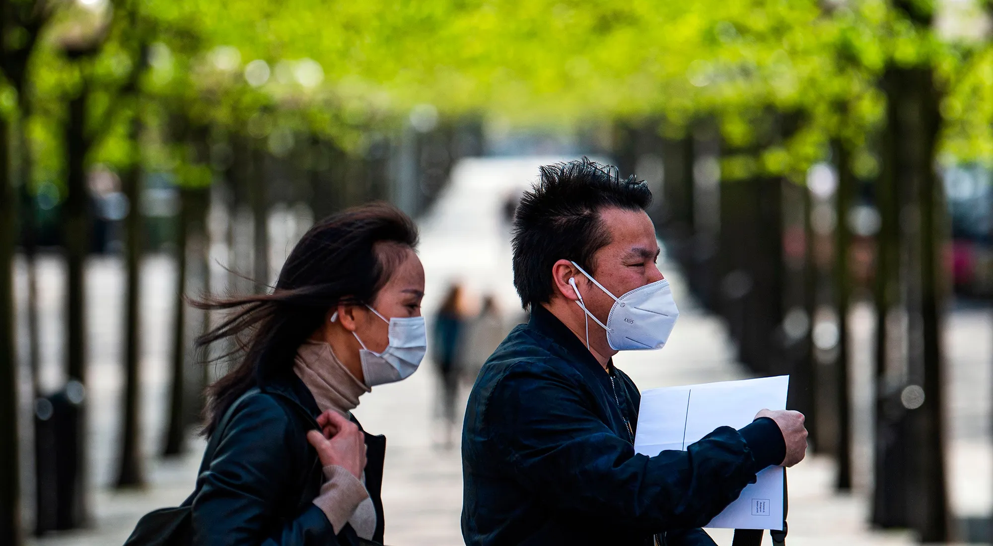 A man and a woman wear protective face masks.