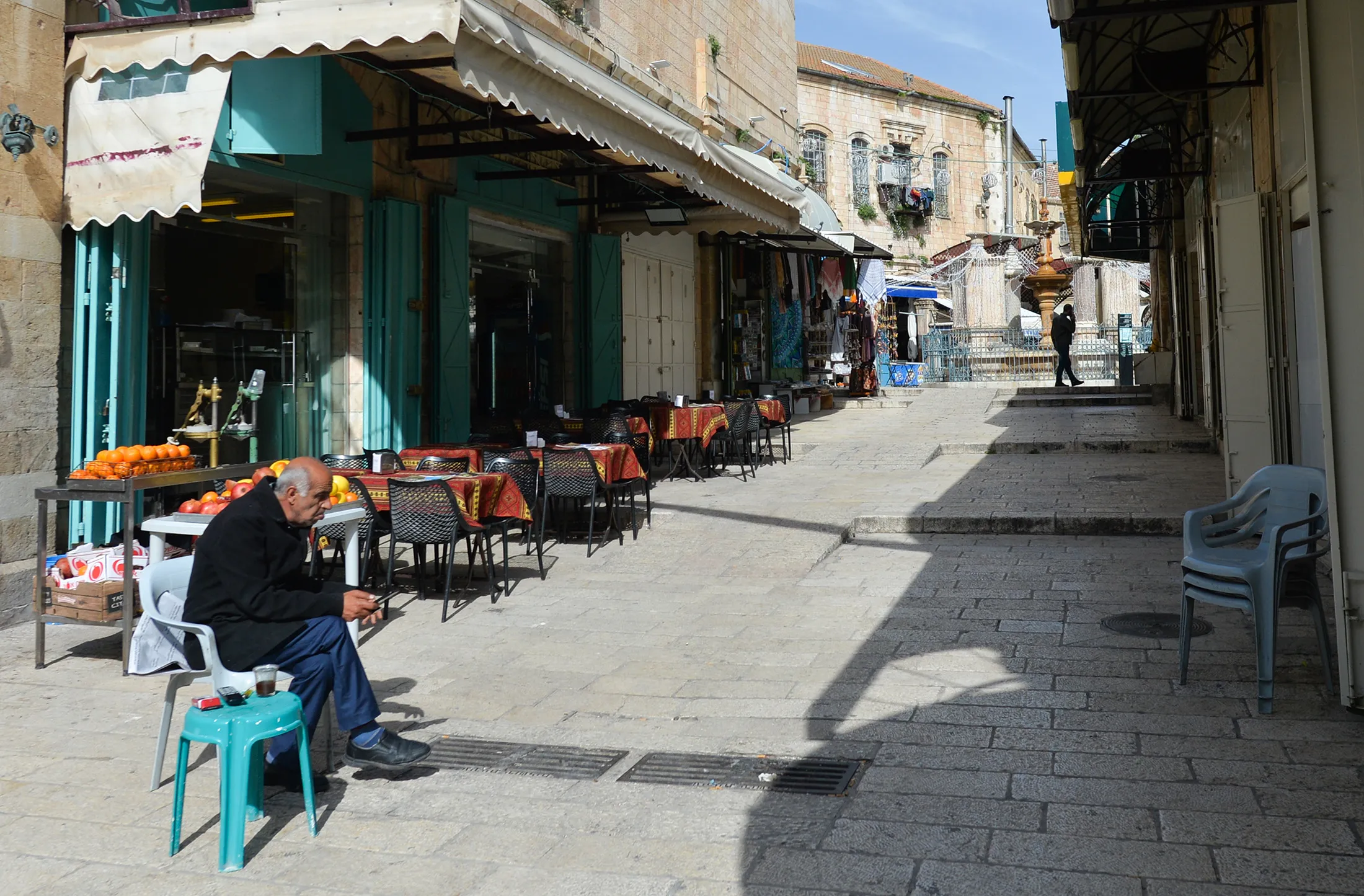 A man sits at a cafe on an empty street in Jerusalem's Old City&nbsp;on March 10.&nbsp;