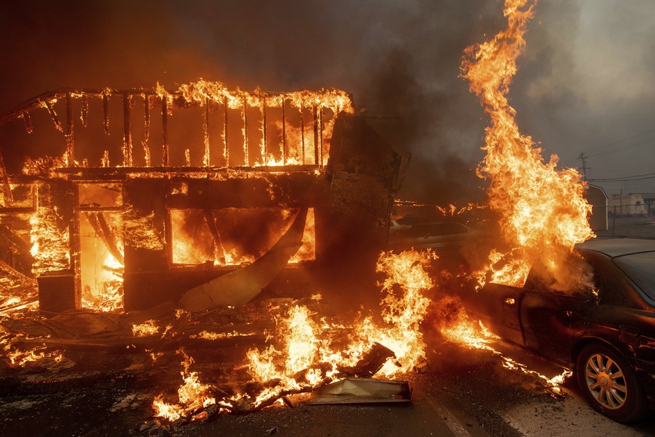 Flames consume a car and building as the Camp Fire tears through Paradise, California, on Thursday.