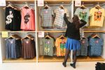An employee arranges t-shirts displayed at Fast Retailing Co.\'s Uniqlo store in the Ginza district of Tokyo, Japan, on Wednesday, April 10, 2013. Fast Retailing, Asiaâs largest apparel retailer, is scheduled to announce earnings tomorrow.